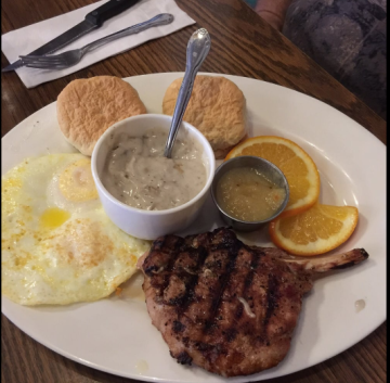 Egg breakfast with biscuits and pork chop.
